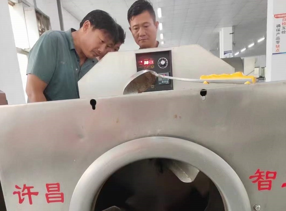 河南老乡来厂试机电磁炒货机炒制瓜子现场订机